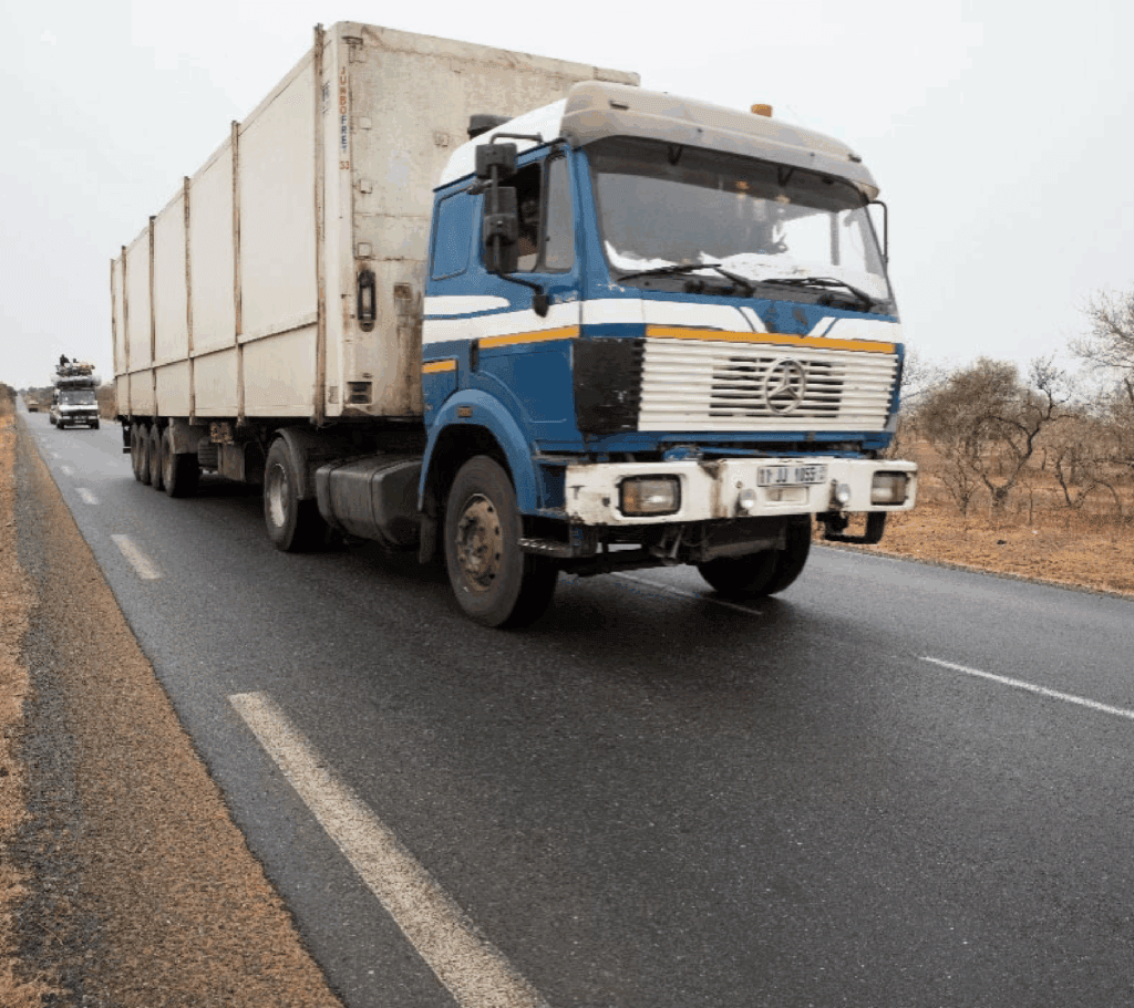 Big blue and white truck driving on the road.